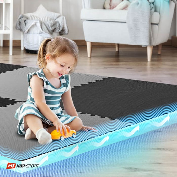 Bambino seduto sul tappetino puzzle nero-grigio Hop-Sport 2cm 8 pezzi