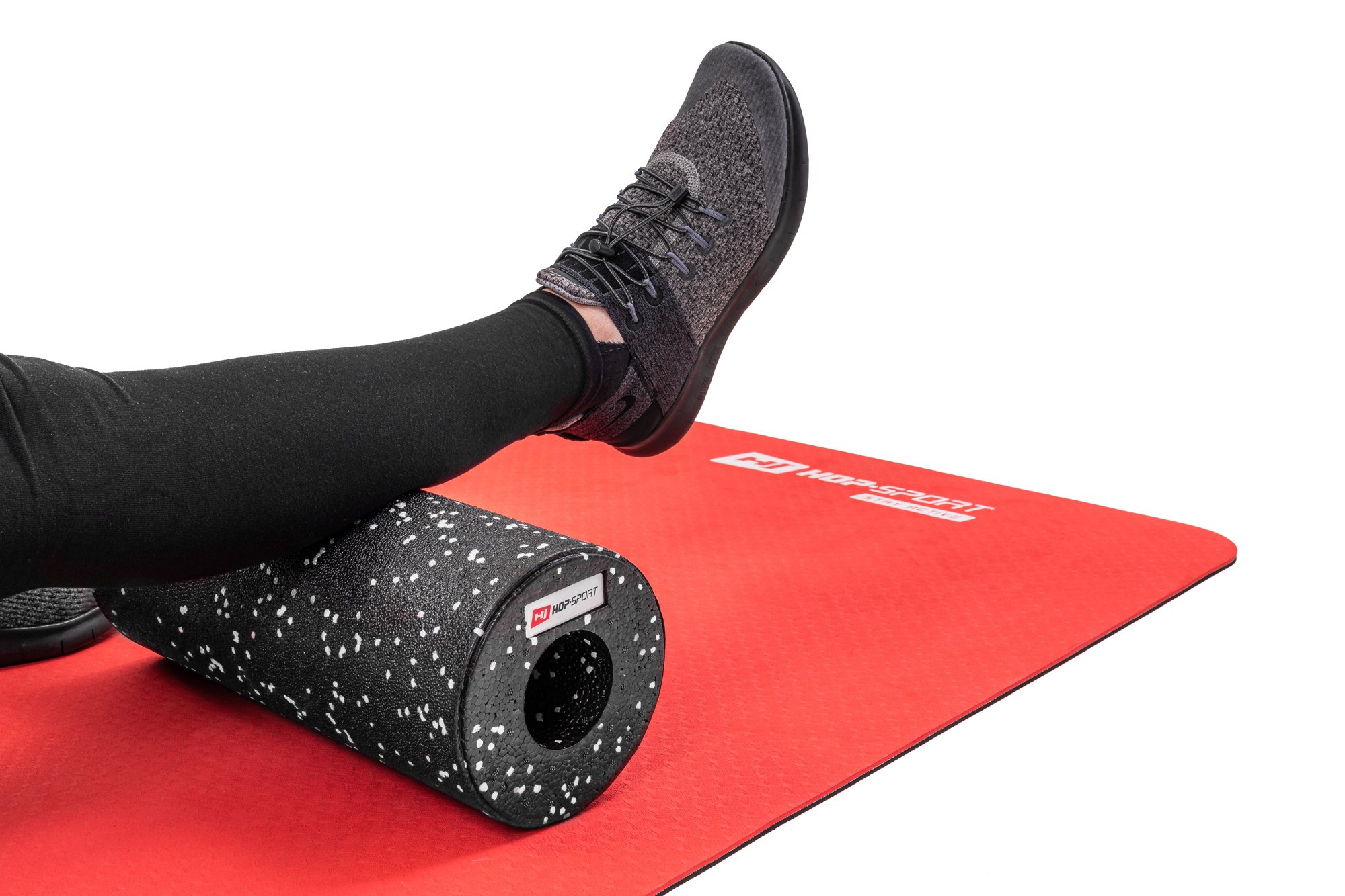 Massaggio dei muscoli del polpaccio con un rullo EPP bianco e nero