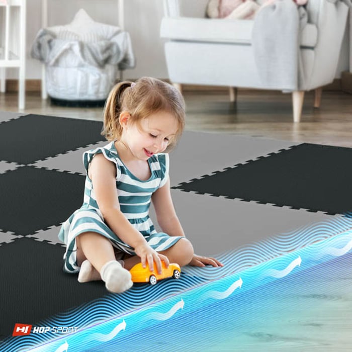 Bambino seduto sul tappetino puzzle nero-grigio Hop-Sport 2cm 12 pezzi
