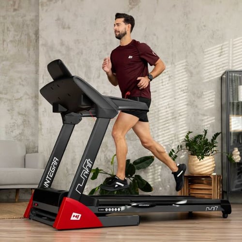 un uomo corre sul tapis roulant Hop-Sport nel suo appartamento