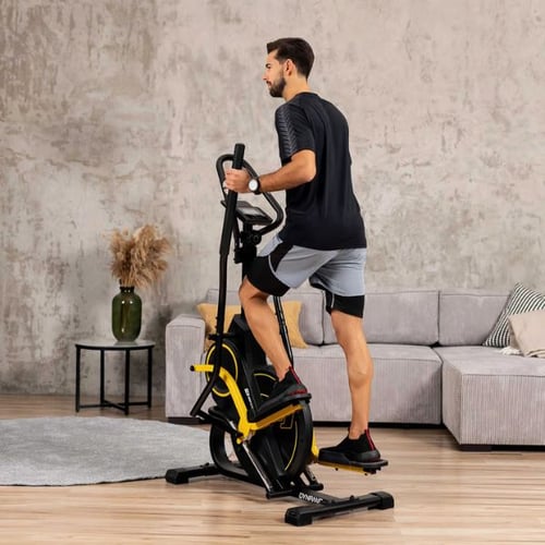 Un uomo si allena sull'ellittica Hop-Sport nel suo appartamento