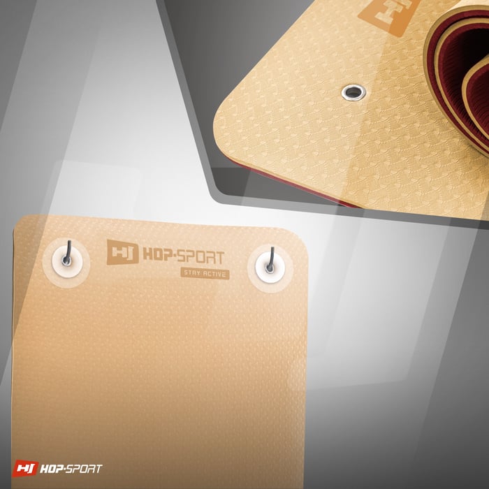 Fori pratici che permettono di appendere il tappetino TPE in colore arancione-rosso del marchio Hop-sport
