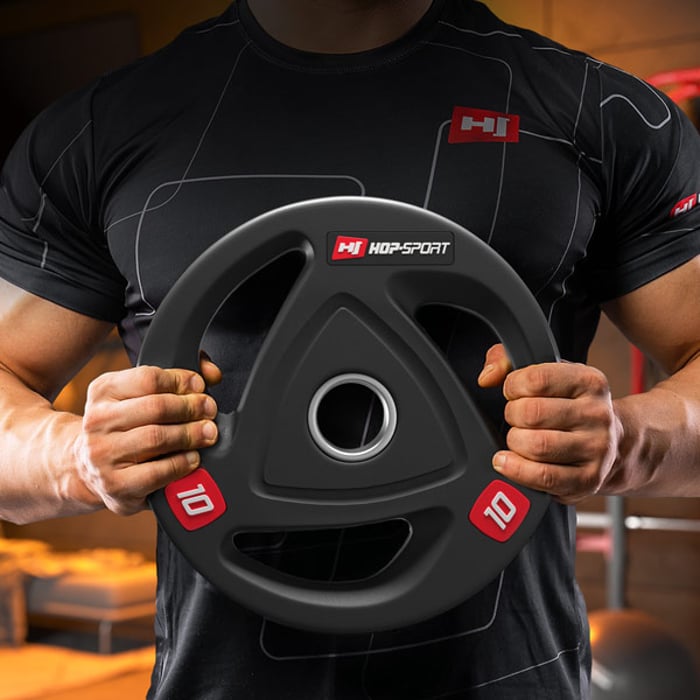 Ragazzo che tiene in mano un peso olimpico del marchio Hop-sport