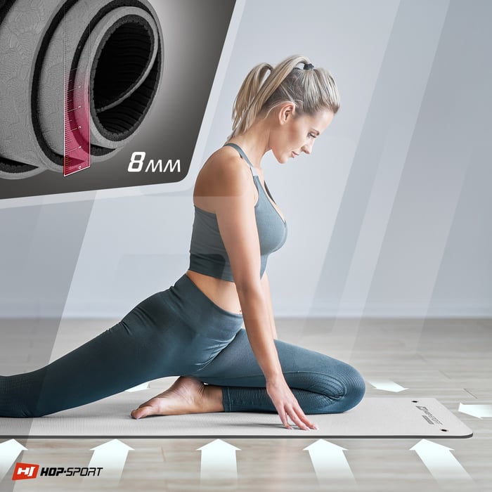 Ragazza che si allena su un tappetino TPE con fori per appendere di colore grigio del marchio Hop-sport
