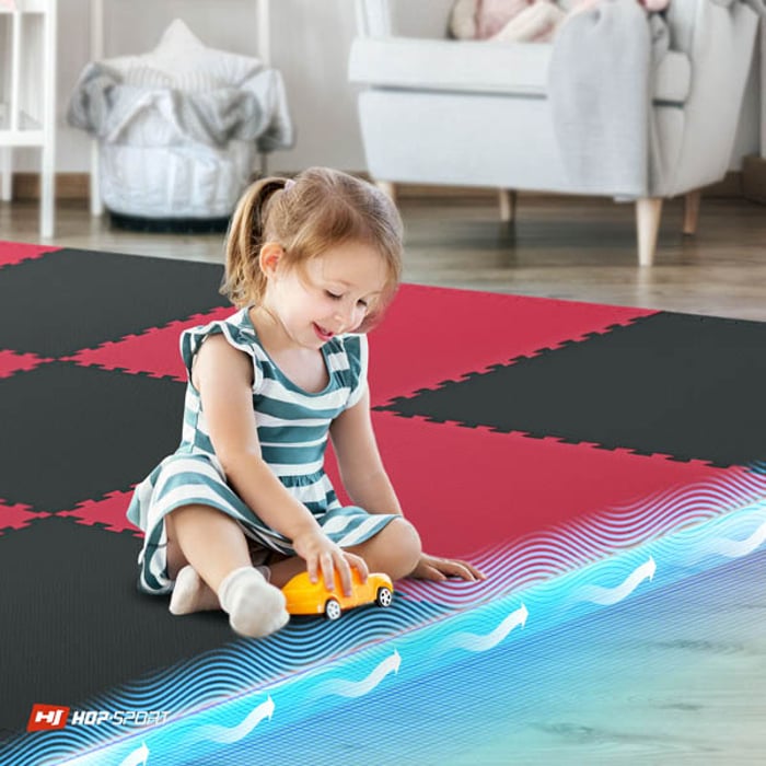 Bambino seduto sul tappetino puzzle nero-rosso Hop-Sport 2cm 12 pezzi