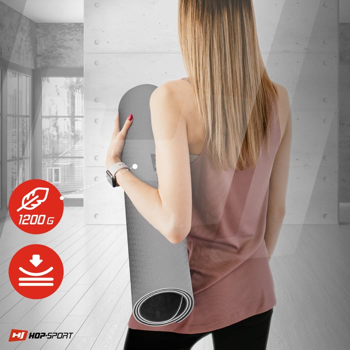 Ragazza che tiene un tappetino TPE 0,8cm arrotolato di colore grigio del marchio Hop-sport