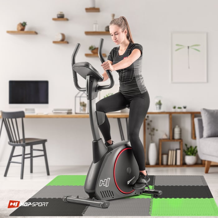 Ragazza che si allena su attrezzature fitness posizionate sul tappetino puzzle nero-grigio-verde