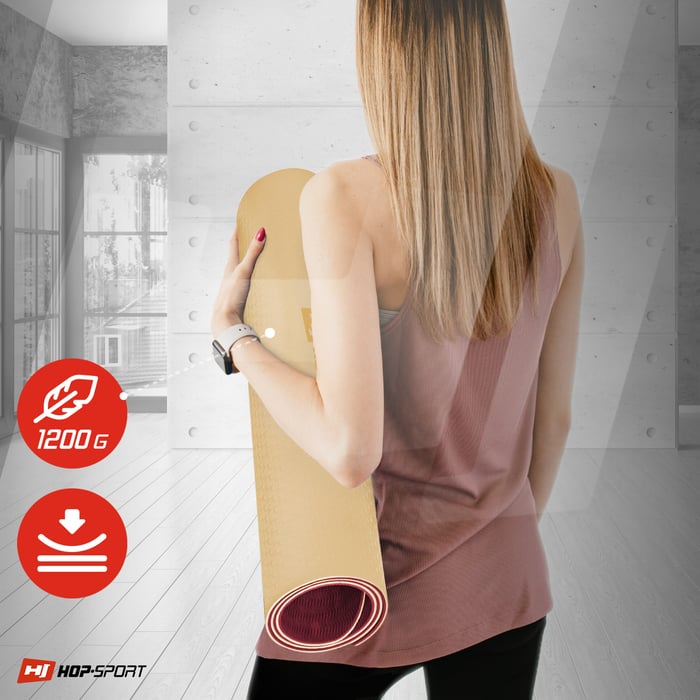 Ragazza che tiene un tappetino TPE 0,8cm arrotolato in colore arancione-rosso del marchio Hop-sport