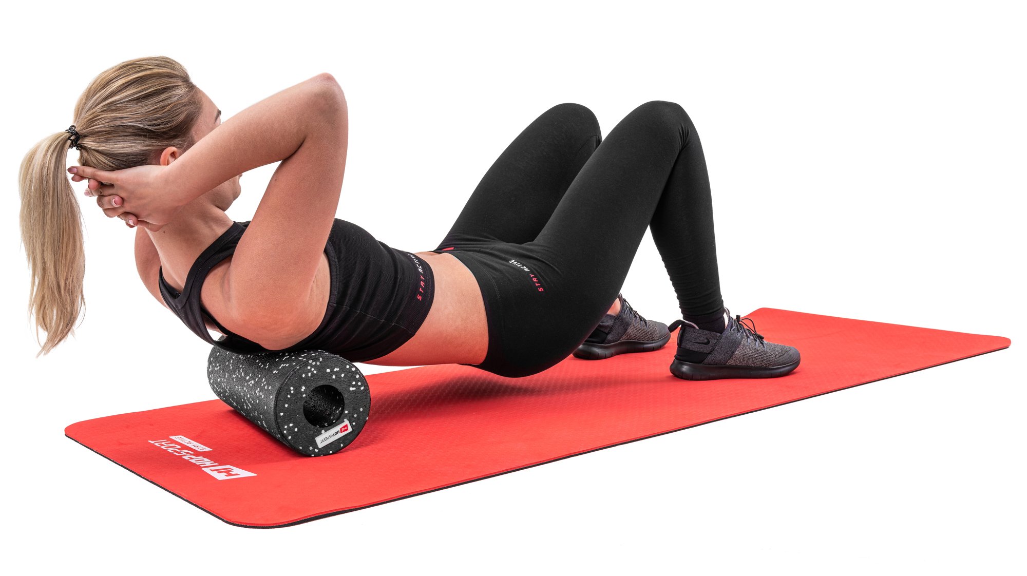 Donna che massaggia i muscoli della schiena con un rullo lungo 33cm nero a pois bianchi